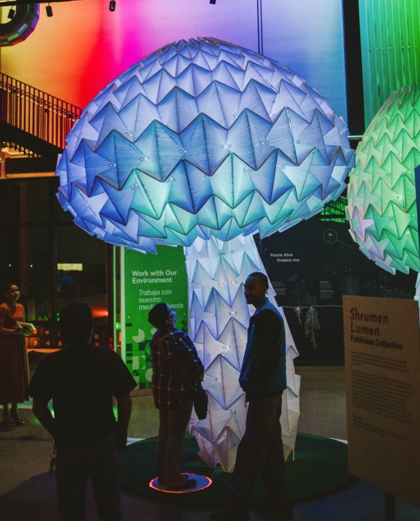 People look up at an illuminated sculpture at the Lumimarium in Omaha, Nebraska